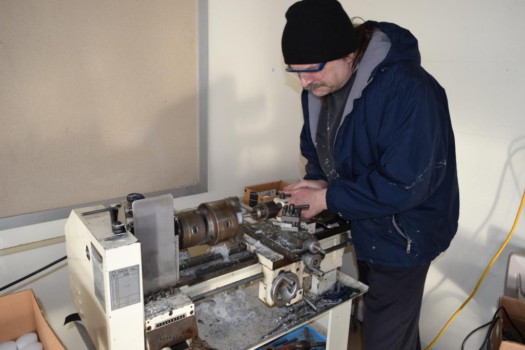 John Siegel machining custom parts for Robotic Arm - man wearing a blue jacket